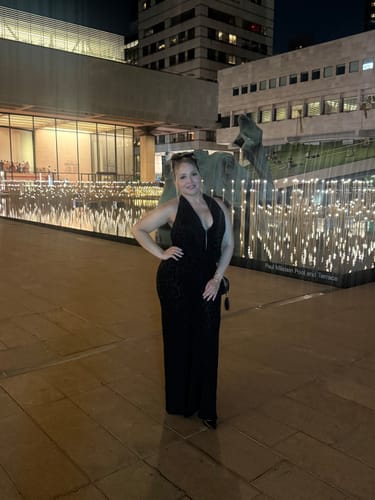 Customer's Burnout Halter Open Back Jumpsuit worn at night in an outdoor city setting.