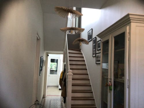 Customer's Cygnes Trio suspension lampes installées dans une entrée lumineuse au-dessus d'un escalier en bois