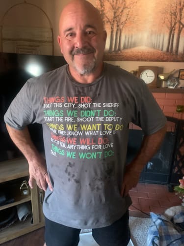 Customer's gray Things We Did T-Shirt worn by a person, featuring text about classic rock songs in colorful font.