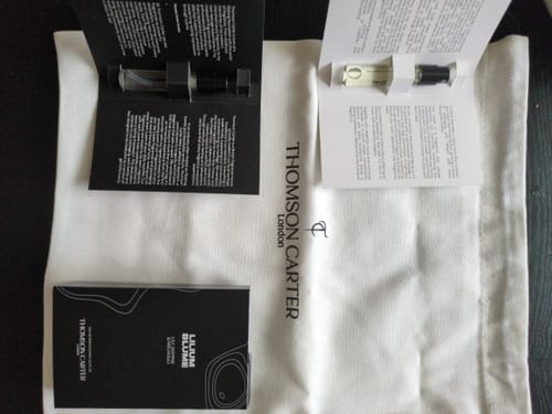 Customer's Lilium Blume perfume box, two scent sample vials, and branded drawstring bag on a surface.