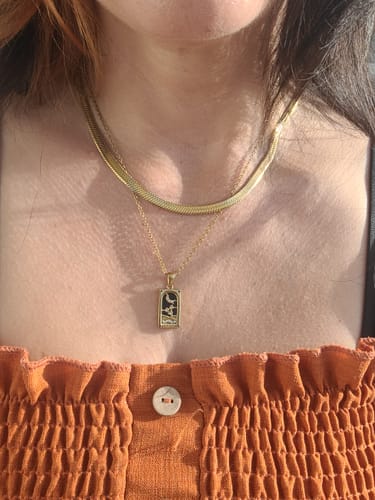 Reviewer wearing a gold Golden Fortune Necklace layered with a gold chain against their neck.