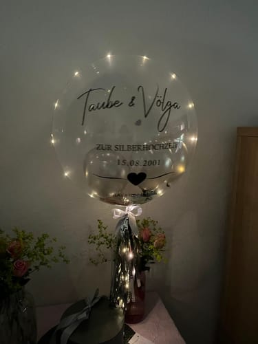 Kunden-Geschenkbox Rund mit einem leuchtenden Designer-Ballon zur Silberhochzeit, der über dem Karton schwebt.