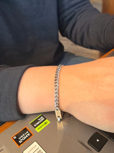 Customer's polished stainless steel Cuban link bracelet worn on their wrist