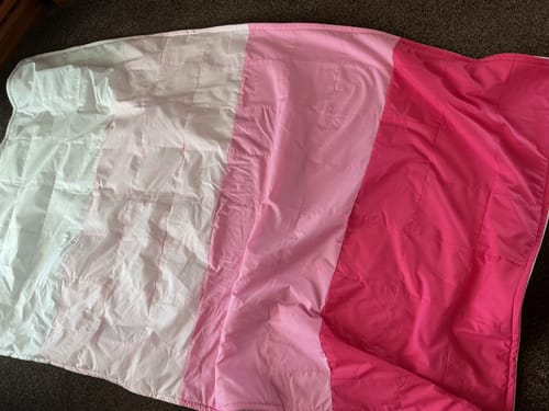 Customer's handmade blanket made from strips of plain polycotton fabric in shades of white, pink, and dark pink.