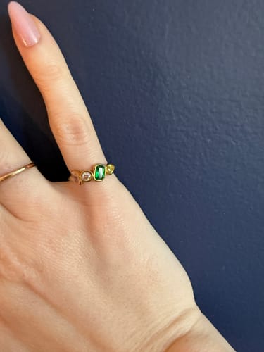 Customer's Nova Birthstone Ring with multiple colorful, dainty stones worn on a finger.