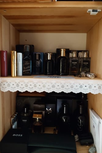 Customer's Smoke & Mirrors Eau de Parfum displayed on a wooden shelf among a collection of various fragrance bottles.