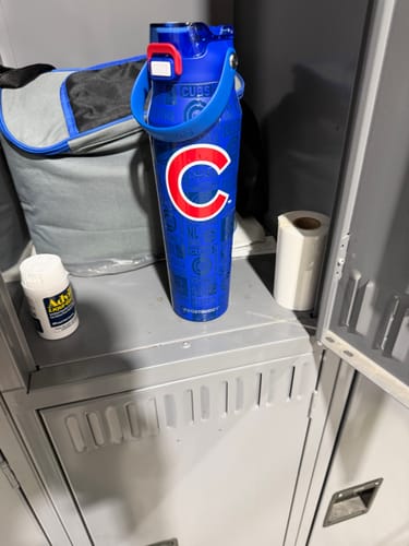 Customer's blue Chicago Cubs Bottle Buddy sitting on a shelf inside a locker with personal items.