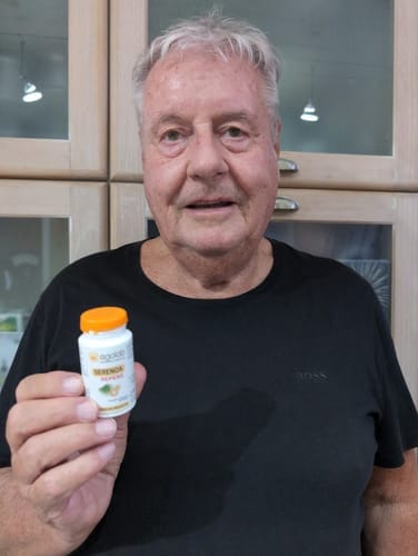 Reviewer holds a small bottle of 3 Conf. Serenoa Repens supplement in their hand.