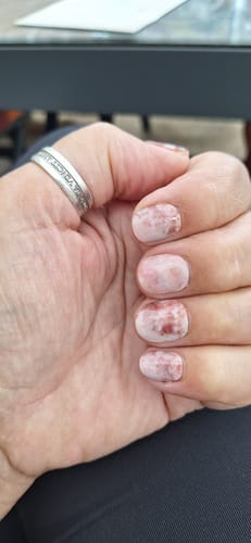 Reviewer's Hand mit UV Gel Nail Wraps in Dreamy Blooms mit zartem Blumenmuster.