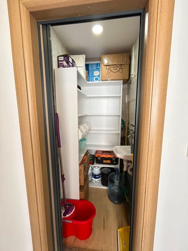 Müşterinin Rani KC106 köşe banyo dolabı, küçük bir tuvalet alanında rafları dolu ve ayakları takılmamış halde yerleştirilmiş