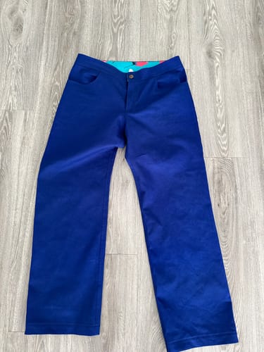 Customer's Royal Blue Cotton Drill Fabric sewn into mid rise straight leg trousers on a wooden floor.