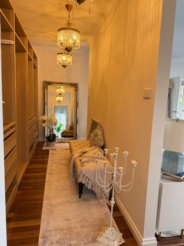 Customer's cream Laëtitia floor candelabra placed in a hallway, showing its nine-armed metal design.