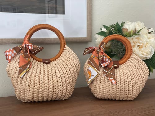 Customer's two finished CrochetPark Shell crochet handbags with round wooden handles and decorative silk ribbons.