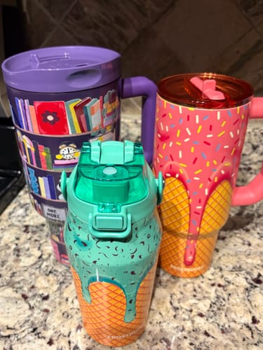 Customer's colorful Thicc Buddy mug collection including a purple book-themed mug and ice cream cone-style tumblers.