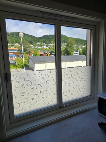 Customer's Static Scroll Flower vindusfolie montert på vindu med et frostet, dekorativt mønster av bladranker.