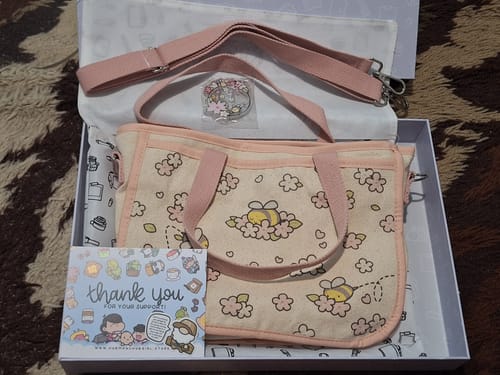 Customer's Shipping Protection package featuring a canvas bee-patterned bag, a small pin, and a thank you card.