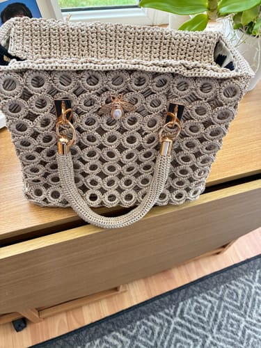 Customer's completed Garden Bee Crochet Bag, featuring a gold-tone bee charm and structured mesh design.