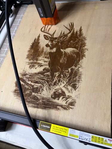 Customer's AtomStack A20 Pro V2 laser engraving a detailed deer scene onto a flat wooden board.
