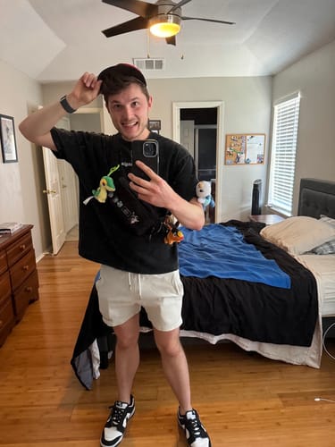 Customer's black Core Relaxed Tee worn in a bedroom mirror selfie, showing a loose fit.