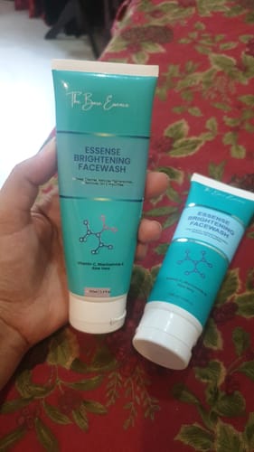 Customer's hand holding two tubes of Essense Brightening Facewash from the product bundle.