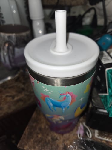 Customer's unicorn-themed CREWCUP tumbler with white lid and straw sitting on a kitchen counter.