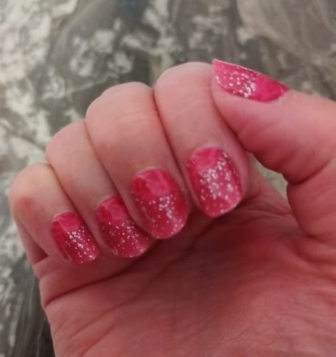 Customer's hand showing UV Gel Glitter Rose Ombré nail wraps with floral pattern and glitter finish.