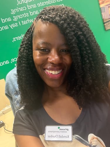 Customer wearing natural black Multi-Textured Kinky Curly Crochet Hair extensions, smiling at the camera.