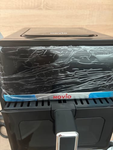 Customer's black Novio StonePro air fryer with protective plastic film on the front panel.