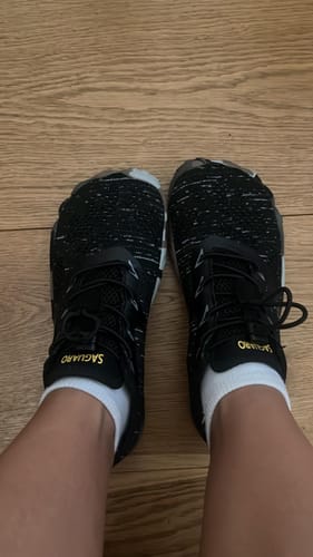 Customer's Smart II Barfußschuhe, worn on feet with white socks on a wooden floor.