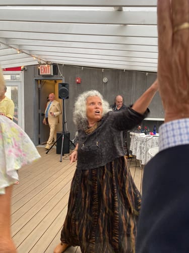 Reviewer dancing at a wedding in a long, spliced two-piece set featuring a loose, patterned top and skirt.