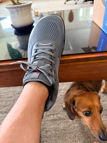 Customer's gray CUURT Muuv court shoe being worn, showing the wide toe box design.