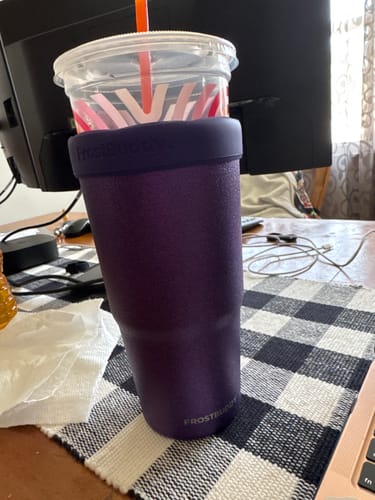 Customer's purple To-Go Buddy cup insulator holding a plastic drink cup on a desk.