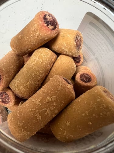 Customer's Hemp & Tails Savory Beef Rolls inside a clear plastic container, showing several rolled dog treats.