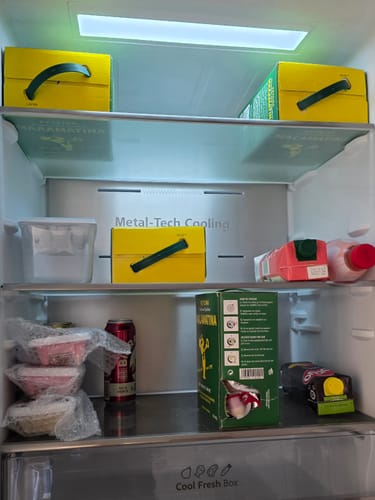 Customer's stash of several yellow 3L Malamatina Retsina boxes stored inside a well-stocked home refrigerator.