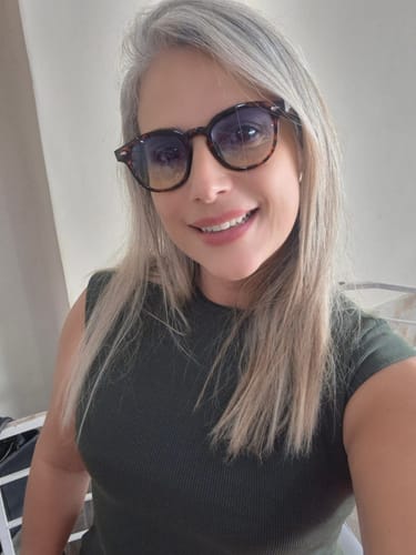 Customer's selfie wearing stylish tortoise shell glasses, smiling while testing out their new purchase.
