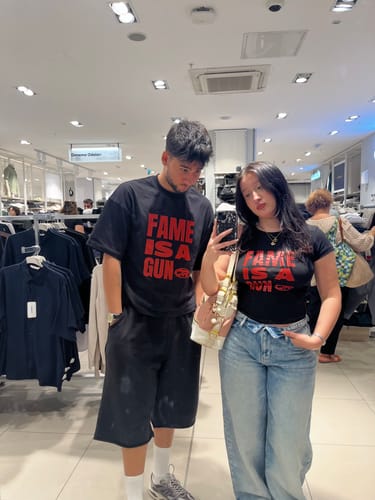 Customer's JR Red Fame Baskılı Siyah Boxy Fit Tshirt worn in a mirror selfie while shopping in a store.