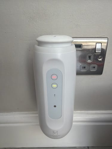 Customer's white ZenPlug waterless diffuser plugged into a wall outlet, with two illuminated setting lights.