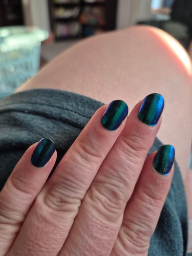 Customer's Hand mit UV Gel Feelin' Lucky Nail Wraps, glänzend blau-grün, nach einer Woche Tragezeit.