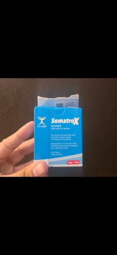 Customer's hand holding a blue Somatrox XT Labs product box.