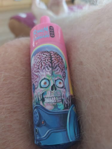 Customer's pink RandM Tornado 9000 disposable vape with alien skull graphic held in hand.