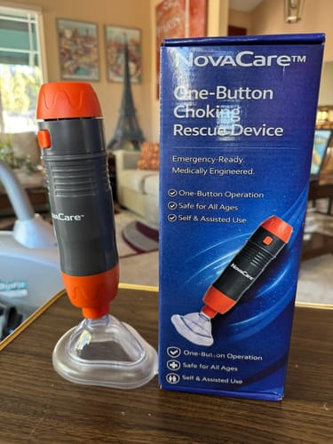 Customer's NovaCare choking rescue device with a clear mask, standing next to its blue product box on a table.