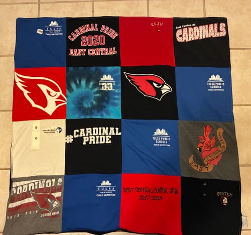 Customer's Project Repat T-Shirt Quilt featuring a patchwork design of colorful school jerseys on a tiled floor.