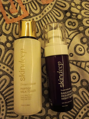 Customer's Bakuchiol Resurfacing Night Serum in a purple bottle standing next to a bottle of Skindeep Peptide Milk Toner.