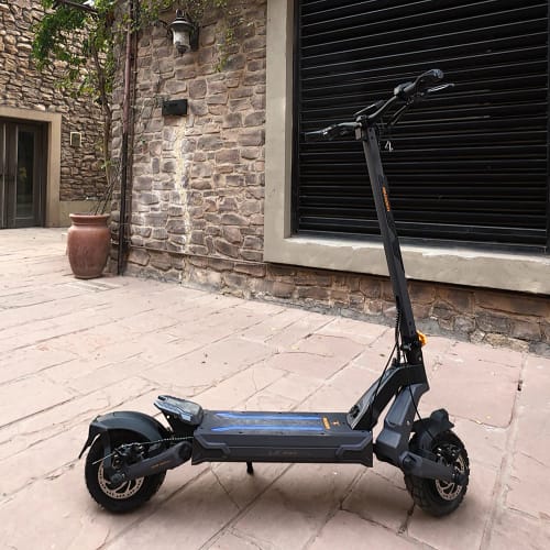 Customer's Ausom L2 Max electric scooter standing on a stone patio outside a building.