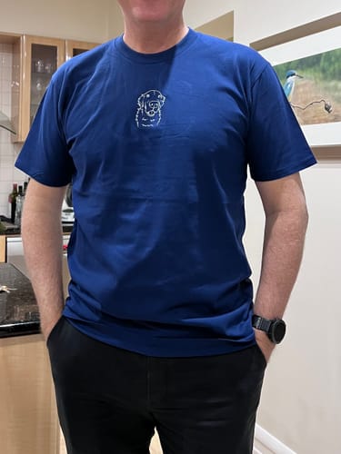 Customer's blue CUSTOM Men's Pet T-Shirt with white embroidered pet portrait on chest worn by a person.