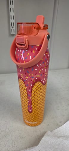 Customer's pink Bottle Buddy tumbler with ice cream cone pattern, standing upright on a light surface.