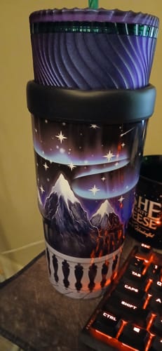 Customer's Mystery To-Go Buddy sleeve wrapped around a tall cup featuring a mountain landscape with starry sky.