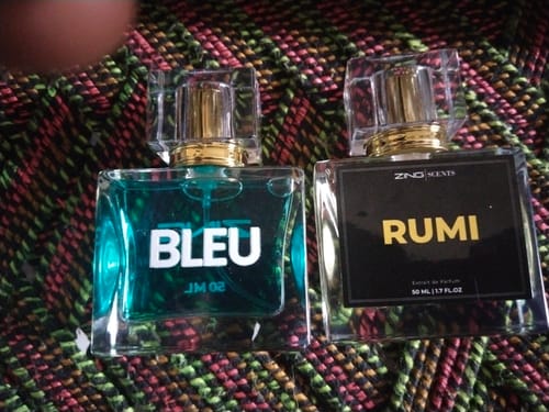 Customer's two glass perfume bottles from The Royal Oud Collection sitting on a patterned fabric surface.