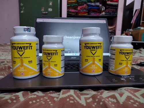 Customer's four white and yellow YouWeFit Omega-3 Fish Oil bottles arranged in a row on an open laptop