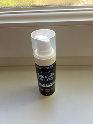 Customer's Sebovia Essence face cream bottle standing on a light surface near a window.